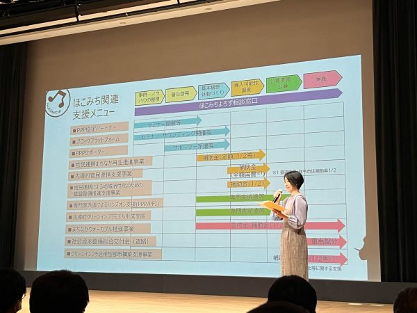 国土交通省 総合政策局の梶原ちえみさん。地域でのほこみち制度の上手な活かし方や官民連携手法や支援メニューを発表。メモをするために、会場のあちこちからシャッター音が