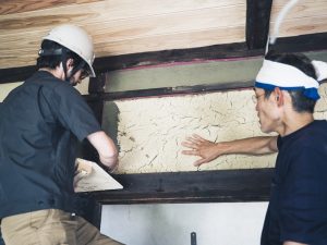 プロの指導を受けながらせんとうとまちの関係者もせっせと塗る<br>Photo：TADA