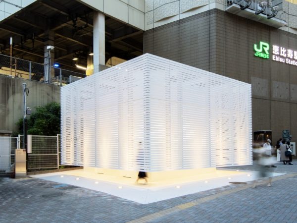 恵比寿駅西口の駅前交番横にある「恵比寿駅西口公衆トイレ」（2021年7月オープン）。グラフィックデザインやブランド戦略のプロデュースなど、幅広い領域で活動中のクリエイティブディレクター、佐藤可士和さんがデザインを手がけた。「毎日見る駅前のシンボルとして、極端に目立ちすぎないことを大切に考えた」とのことで、シンプルな白を基調にした外観になっている。建物はアルミ製の白いルーバーで囲われ、軽やかな印象</BR>（撮影：永禮賢、提供：日本財団）

