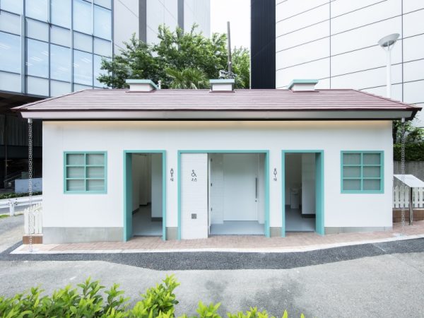 タコの滑り台（写真手前）があることから「タコ公園」の愛称で親しまれている恵比寿東公園のトイレを手がけたのは、建築家の槇文彦さん。写真奥の白い建物がそのトイレ「恵比寿東公園トイレ」（2020年8月オープン）だ。屋根のひらひらとしたカーブが印象的で、槇さんは「イカトイレ」と名付けた。「休憩所を備えた公園内のパビリオン」をテーマに、男性用、女性用、ユニバーサル・トイレを分散して配置。中央には中庭が設けられ、壁面にはベンチが備え付けられている</BR>（撮影：永禮賢、提供：日本財団）