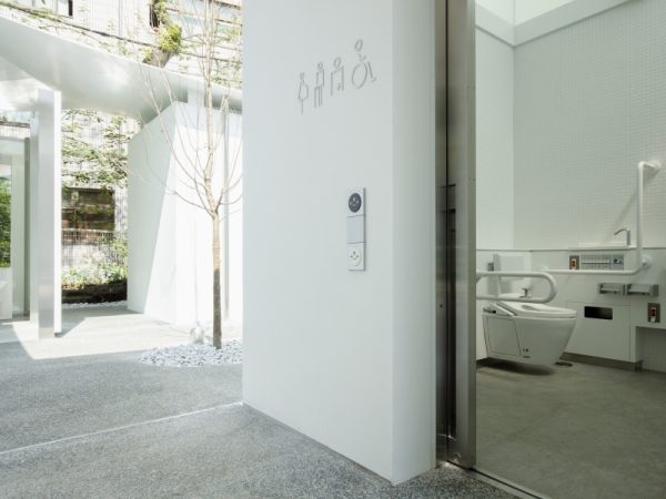 タコの滑り台（写真手前）があることから「タコ公園」の愛称で親しまれている恵比寿東公園のトイレを手がけたのは、建築家の槇文彦さん。写真奥の白い建物がそのトイレ「恵比寿東公園トイレ」（2020年8月オープン）だ。屋根のひらひらとしたカーブが印象的で、槇さんは「イカトイレ」と名付けた。「休憩所を備えた公園内のパビリオン」をテーマに、男性用、女性用、ユニバーサル・トイレを分散して配置。中央には中庭が設けられ、壁面にはベンチが備え付けられている</BR>（撮影：永禮賢、提供：日本財団）