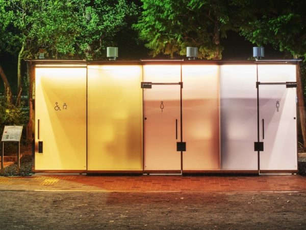建築家の坂茂さんがデザインした”透明トイレ“は、「代々木深町小公園トイレ」と「はるのおがわコミュニティパーク」の2ヶ所（ともに2020年8月オープン）。写真は「代々木深町小公園トイレ」。外壁のガラスが透明で、トイレに入る前に内部がきれいかどうか、誰かが隠れていないかを確認できる。夜にはライトアップされ、公園を照らす</BR>（撮影：永禮賢、提供：日本財団）</BR>※「代々木深町小公園トイレ」と「はるのおがわコミュニティパークトイレ」は、2022年12月中旬より、ガラス壁の不具合のため、当面は常時、不透明の状態で運用

