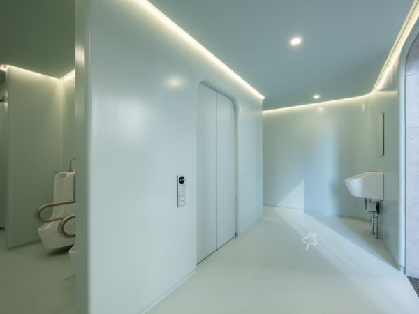 山手通り沿い、代々木八幡宮の森を背にして建つ「代々木八幡公衆トイレ」（2021年7月オープン）。建築家の伊東豊雄さんが手がけたトイレで、キノコのような親しみやすい外観のトイレが３つ、設けられている。３つの個室型トイレ（ユニバーサル・トイレ、男性用、女性用）を分散させて配置し、行き止まりがなく、視線が抜けるというつくりで防犯性を高めている。筆者は晴天の午後に現地を訪れたが、屋根の間のスリットから自然光が入ってきて明るく、心地よく感じられた</BR>（撮影：永禮賢、提供：日本財団）