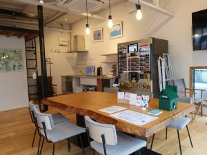 キッチン、トイレ、自販機、テーブルなどが用意されており、一休みはもちろん、ちょっとパソコンを開いて作業、ということも可能。こちら側にも絵が飾られている