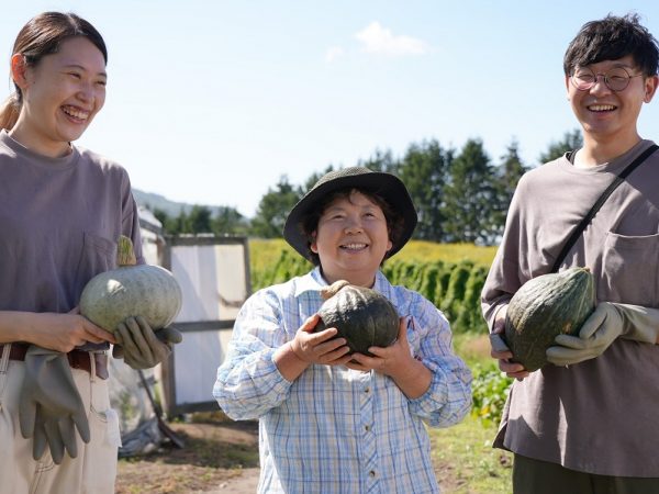 野菜を育てる近隣住民と交流する寺江さん夫婦（平賀さん提供）
