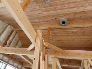 工事中の室内。木の柱、梁に分厚い断熱材、天井にあるのはびおソーラーの心臓部にあたるソーラーファンボックス
