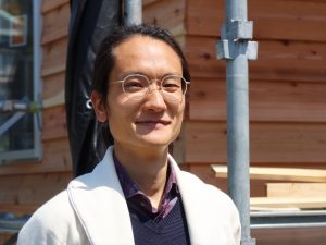 建設中の建物の前で石井さん。柔和な雰囲気が印象的だった