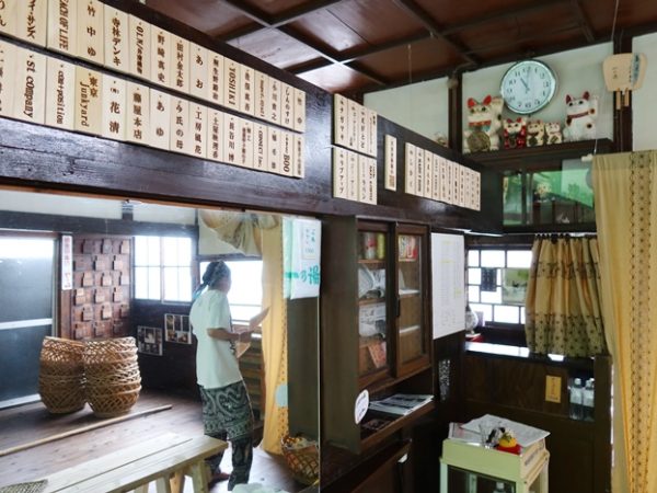 浴室の手前から番台方向。クラウドファンディングに参加してくださった方々の名前のある部分はもともとは無かった。また、番台脇のカーテンも目隠しのために新たに付けた