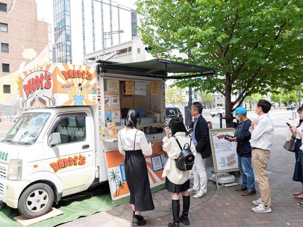 「新虎ストリートマルシェ」は、新橋と虎ノ門を結ぶ新虎通りを会場としたイベントだ。多彩なお店や新橋や虎ノ門にゆかりのある老舗や新事業の店舗が軒を連ねて来場者をもてなし、地域ににぎわいをもたらす契機となった。