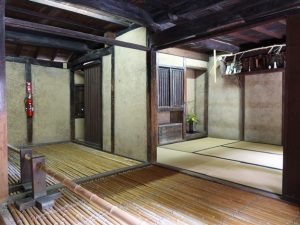 土間から上がったところは竹のすのこ敷きという吉野家住宅。住宅周囲には強風を防ぐための石垣が築かれていた