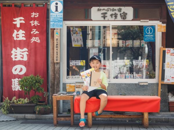 旧日光街道の100個の地口行灯の中にヒントがある謎解きラリーのチラシ（おもて）。2023年9月1日〜11月30日、千住ほんちょう商店街（千住1〜2丁目）、宿場町通り商店街（千住3丁目）、宿場通り商店街（千住4〜5丁目）で開催。参加方法は、チラシを手に入れ、商店街につけられた100個の地口行灯の中から3つの地口絵の近くにある謎カードを探し、なぞなぞを解く。先着180人に1010（せんじゅ）ノートがプレゼントされる（15歳以下のみ）