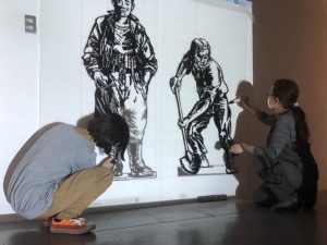 「運河に描く」の制作。投影されたメッツラーさんの線画を参加者がなぞって完成させる手法でパネルが作成された（画像提供：中川運河ギャラリー）