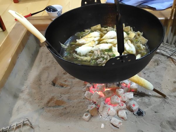 存在感のある茅葺屋根が特徴の「茅葺の曲がり家 西の家」の外観。手前が納屋で奥に母屋がある