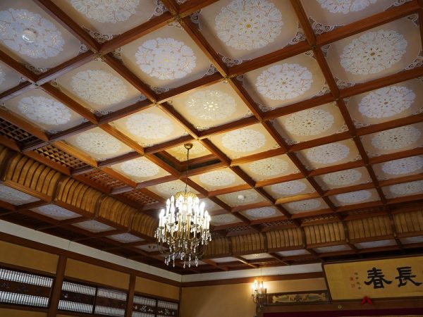 贅を尽くした建築材を使用し、豪華さに目を見張る大広間。正面に見えるのが能舞台。舞台と両脇の鴨居部分の上部に設えられた板には、中村左洲が描いた鳳凰の絵が。鳳凰は神話に登場する鳥で、縁起が良いとされる