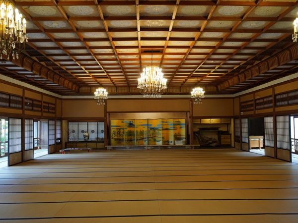 贅を尽くした建築材を使用し、豪華さに目を見張る大広間。正面に見えるのが能舞台。舞台と両脇の鴨居部分の上部に設えられた板には、中村左洲が描いた鳳凰の絵が。鳳凰は神話に登場する鳥で、縁起が良いとされる