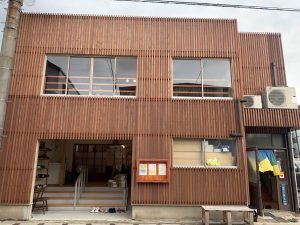 「暮らり」外観。1階左手に見える階段がデイサービス「くらすば」の入り口。2階へは、右の扉から上がることができる。