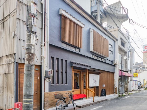 「AREA INN FUSHIMICHO」のカフェラウンジとレセプション。奥のガラスの向こうはコワーキングスペース「halappa」