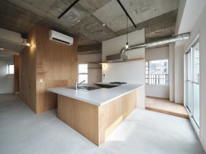 コの字型のカウンターのある302。キッチンの右手に見えているのが寝室、奥はパントリー。冷蔵庫などもここに置く想定（写真：Akira Nakamura）