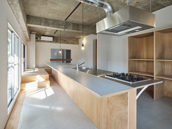 リビングの中心にどん！とキッチン。奥側は小上がりになっている（写真：Akira Nakamura）