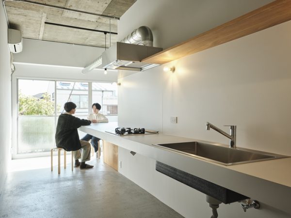 コの字型のカウンターのある302。キッチンの右手に見えているのが寝室、奥はパントリー。冷蔵庫などもここに置く想定（写真：Akira Nakamura）