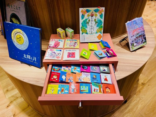 ▲カラフルな引き出しを開けると昔懐かしいミニ絵本がズラリ。「これ、おばあちゃんも小さい頃に読んでた本だよ」などと、世代が離れていても本をきっかけに自然と会話が生まれていく。「最近は電子書籍を好む方も増えていますが、本に実際に触れて探す楽しみもぜひ体験してほしいと思います。流行に左右される本ではなく、10年後20年後も本棚に残していきたい本を選んでいるので、新刊だけでなく古本も置いてあります」と笹本さん