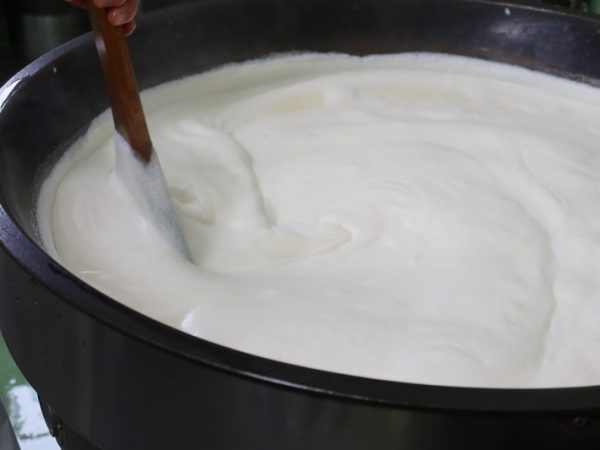 人が手で大きな木べらを使ってかき混ぜ続けるという地味な作り方