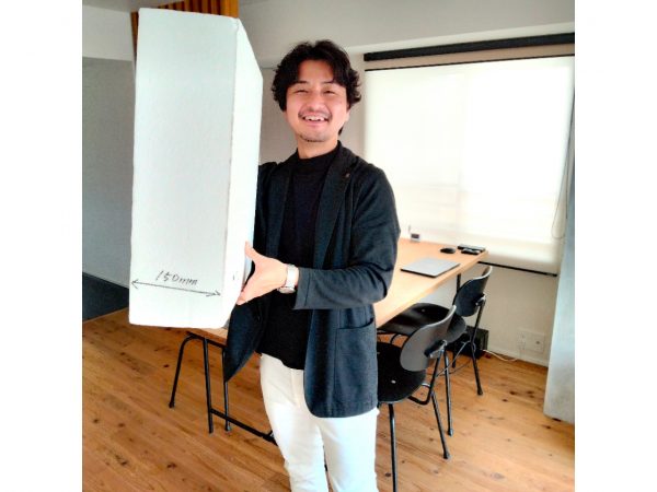 MEGUROHAUSに使用されたのと同じ外断熱材を手にする金田真聡さん（撮影：高橋真樹）