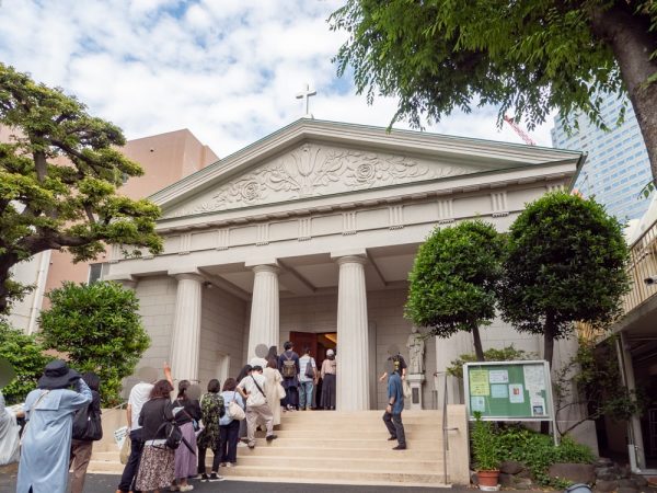 まるでギリシャ・パルテノン神殿のような外観のカトリック築地教会。屋根の妻壁にはユリやバラのレリーフが施されている