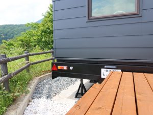 トレーラーハウスを利用した貸別荘。建物の足元を見ると車であること、仮設されていることが分かる