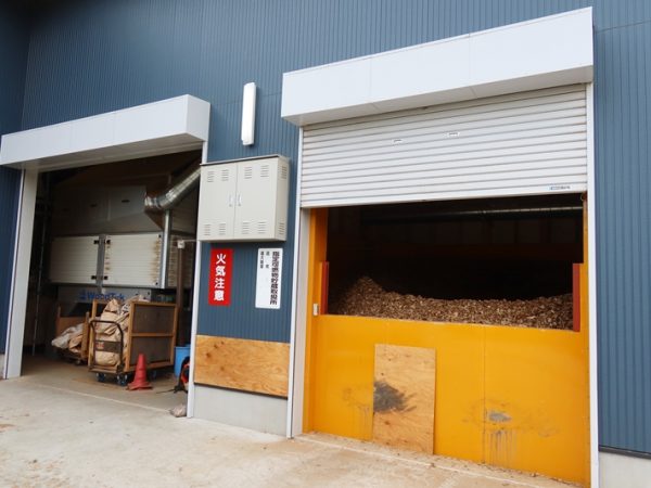 超小型バイオマス熱電併給設備のある建物。右側に見えているウッドチップを燃料にして発電と熱供給を行っている