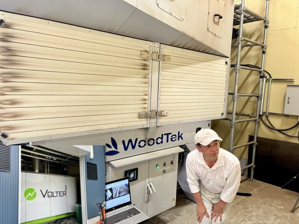 藤和那須リゾート株式会社 飯泉 グループマネージャー。写真の木質チップは自社所有林の間伐等にて発生したもので燃料となる。