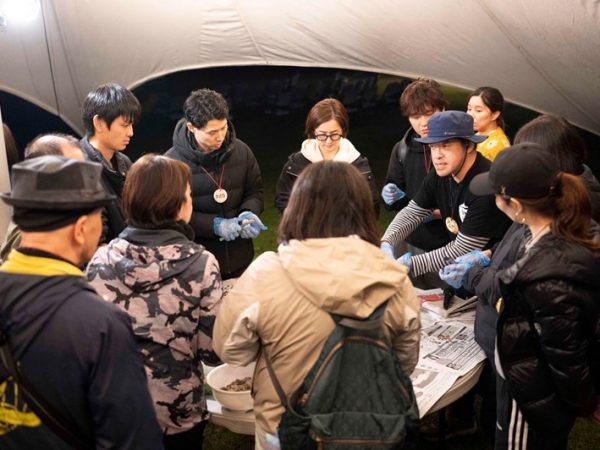 真剣な表情で作り方を説明する黒沼さん（右）