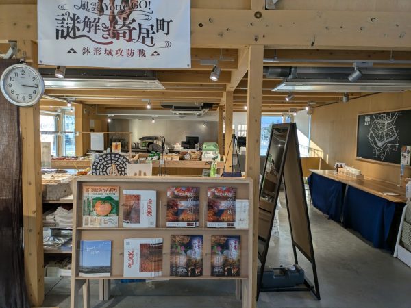 地域おこし協力隊の松本さん。寄居の魅力をYottecoにあるパンフレットを使って紹介する