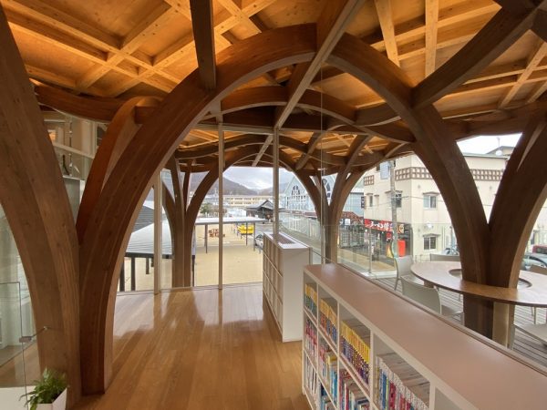 温泉棟1 階の運動浴エリア（水着着用）。レシプロカル構造のヒノキ丸太は、光の中に浮いているよう（写真提供：クアパーク長湯）