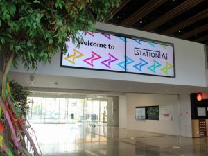 「STATION Ai」のブランドカラー（レインボー）をまとったレインボーツリーやサイネージが出迎えてくれる