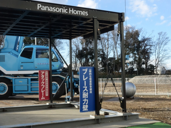 鉄球衝撃実験の様子。手前が一般的なブレース耐力壁。奥がパナソニック ホームズの「アタックフレーム」。ブレース耐力壁はX字になっている一方で、「アタックフレーム」は、ブレース耐力壁より太い鉄骨がK字型になっているのが特徴だ