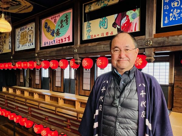 ▲八千代座の管理責任者を務める石橋和幸さんは山鹿市生まれ・山鹿市育ち。東京で建築設計の仕事をしていたが、リタイアして故郷に戻った。「子どもの頃、八千代座の近くに住んでいましたが、私が小学生の頃は既に閉鎖されていてここに芝居小屋があったことすら知りませんでした。八千代座が全国的に注目を集める様になったのは、平成の大修理が完了した平成13（2001）年頃からだったと記憶しています」