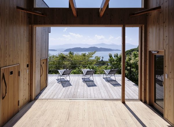 左にウッドデッキ、離れがある。母屋は左側に小さなキッチン的空間、収納があり、右側の２つのドアはいずれもサウナへの入口（撮影/八代写真事務所）