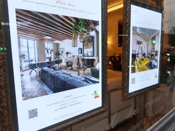 不動産会社の店頭。店頭にはこうしたきれいなディスプレイがあり、室内の写真、条件などが記載されている。右の隅にエネルギーに関する表示がある