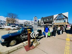 ▲白馬駅前のタクシー乗り場には乗車待ちの観光客が長蛇の列をつくる。筆者も列に並んでみたが、タクシーの台数が足りず30分待ってようやく1台という印象。タクシー不足をカバーするため、スノーシーズンになると他県のタクシー会社から運転手と車両が派遣されてくるそうだ