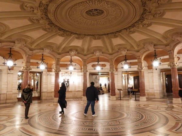 見学する場合に最初に通るのがこの広間。天井が低く、薄暗くなっており、その後に登る大階段との対比が見事。天井にある円形の彫刻にはシャルル・ガルニエ1864ー1875と彫られている。ガルニエ以前は建築家が自分の名まえを建物に残すことはなかったそうだ