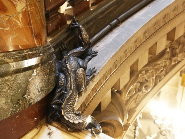 見学する場合に最初に通るのがこの広間。天井が低く、薄暗くなっており、その後に登る大階段との対比が見事。天井にある円形の彫刻にはシャルル・ガルニエ1864ー1875と彫られている。ガルニエ以前は建築家が自分の名まえを建物に残すことはなかったそうだ