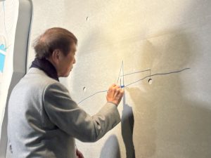内覧会で壁にさらさらとスケッチを描く安藤氏（写真：宮沢洋）