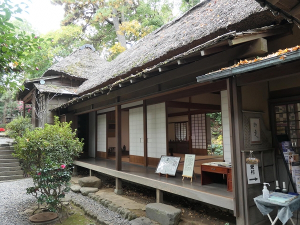 鴫立庵室の外観。和室と濡れ縁のこぢんまりした建物。奥の一段高い場所にあるのは俳諧道場の秋暮亭

