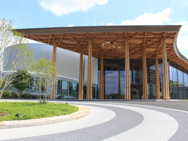 ガラスと木、弧や楕円を取り入れたファサードが特徴。木造の「えんにち空間」と、鉄骨造や鉄筋コンクリート造の「常設展示室」「展示室・管理エリア」「体験室・セミナールーム」という4つの建物で構成されている