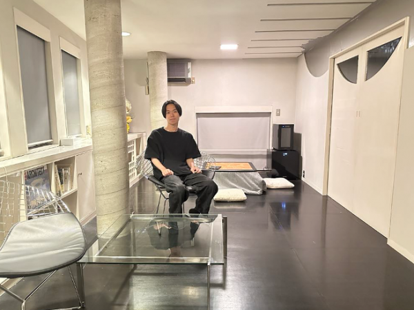 リビングの久野さん。備え付けの冷蔵庫にはクラフトビールが入っている。ビール料金は宿泊料に込み