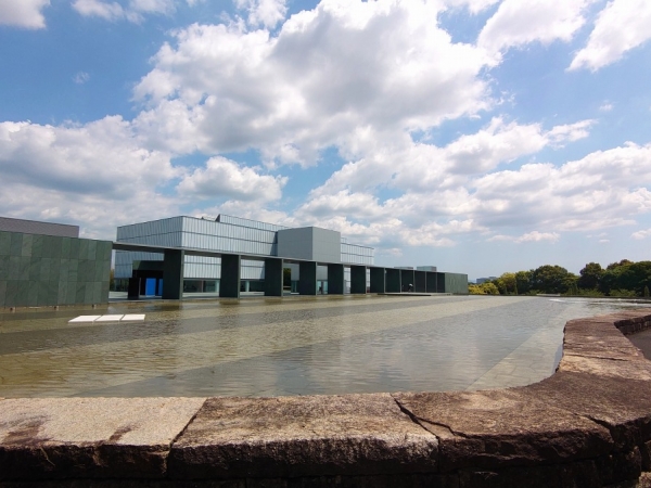 ガラスと木、弧や楕円を取り入れたファサードが特徴。木造の「えんにち空間」と、鉄骨造や鉄筋コンクリート造の「常設展示室」「展示室・管理エリア」「体験室・セミナールーム」という4つの建物で構成されている