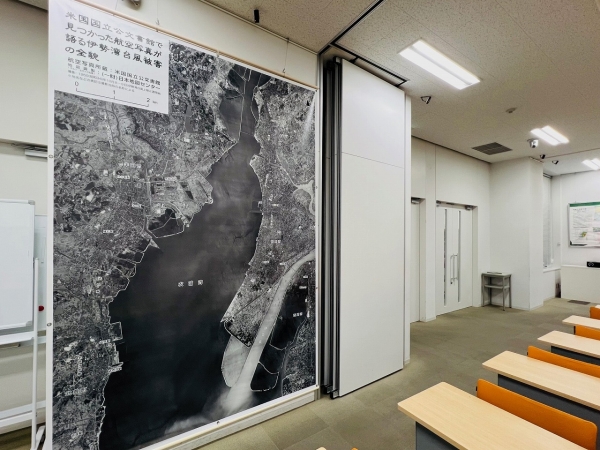 ▲どうしても巨大地震ばかりに関心が向けられがちだが、東海圏では台風や河川氾濫、土砂崩れなど多くの災害危機に直面している。「私も生まれる前のことですが、戦時中の1945年1月には三河地震が発生していますし、1946年には“最後の南海トラフ地震”と呼ばれる昭和南海地震が発生しています。こちらのパネルにある伊勢湾台風は1959年です。つまり何十年かおきに大きな自然災害を繰り返しているわけですから、その災害発生時の緊迫した状況下でどんなことが起きていたのか？を後世に語り継いでいくことも、とても大切な防災対策だと考えています」（写真は減災ホールに展示されている伊勢湾台風被害の航空写真）