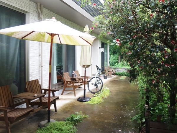 周辺の他の建物と異なり、バルコニーにはさまざまな植物。１階にも溢れんばかりの緑が（写真提提供/bonvoyage株式会社）