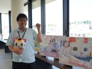 “人を招く”願いを込めて左手を挙げた招き猫ポーズをする常滑市役所経済部観光戦略課主査・森要平さん。2025年4月から現職で、その前はまちづくりに関する部署に所属していた